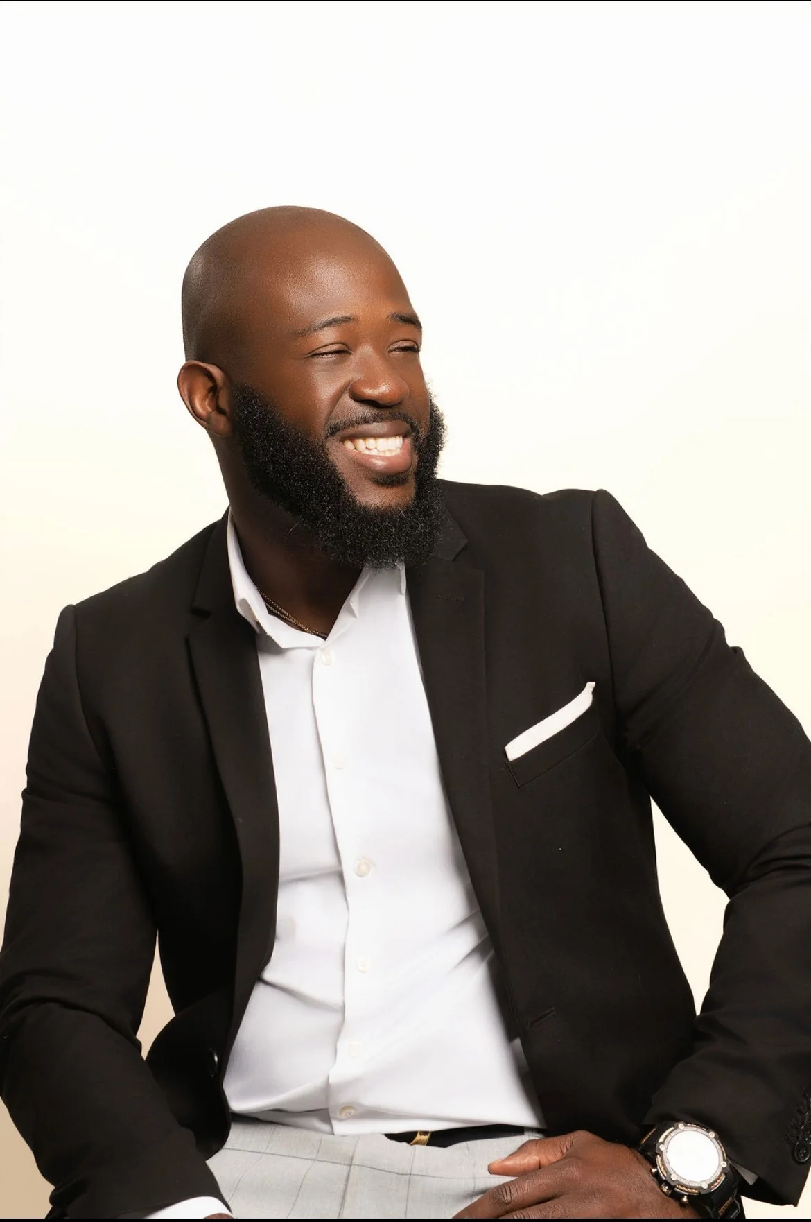 Max Claircius in a black blazer, laughing warmly